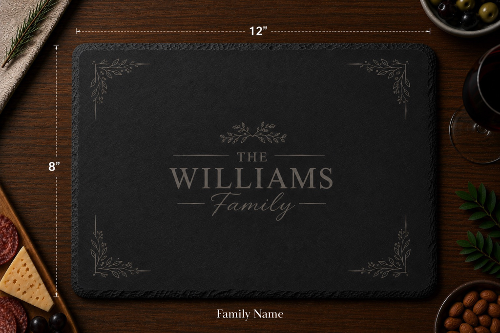 Personalized dark slate cutting board with 'The Williams Family' engraving on a wooden surface.